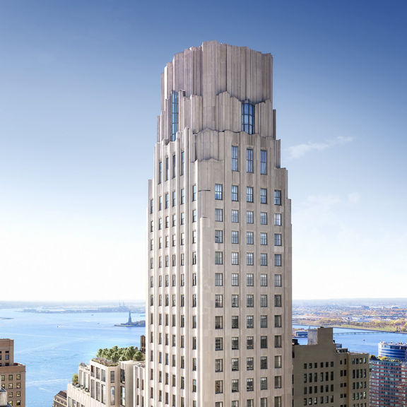 An aerial view of the top of the One Wall Street building, with the statue of liberty in the background