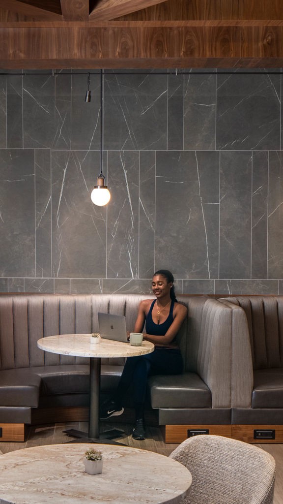 A woman sitting in a booth looking at her laptop