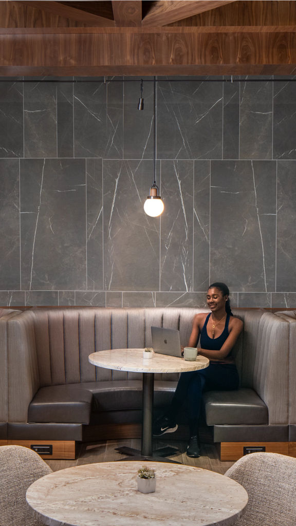 A woman sitting in a booth looking at her laptop