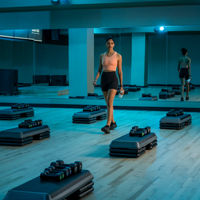A woman in athletic wear walking through an empty group fitness studio