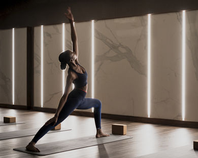 A female completing a reverse warrior pose on a mat in a yoga studio