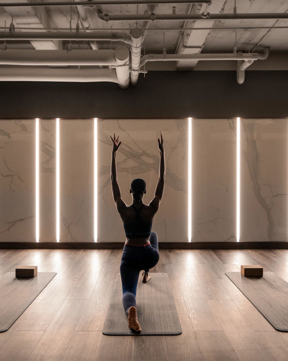 a woman doing a yoga pose in class