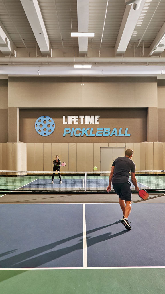 Two adults playing a game of pickleball