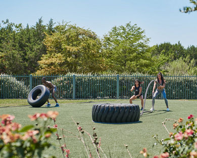 A female dynamic personal trainer showing a member how to properly train with weighted ropes