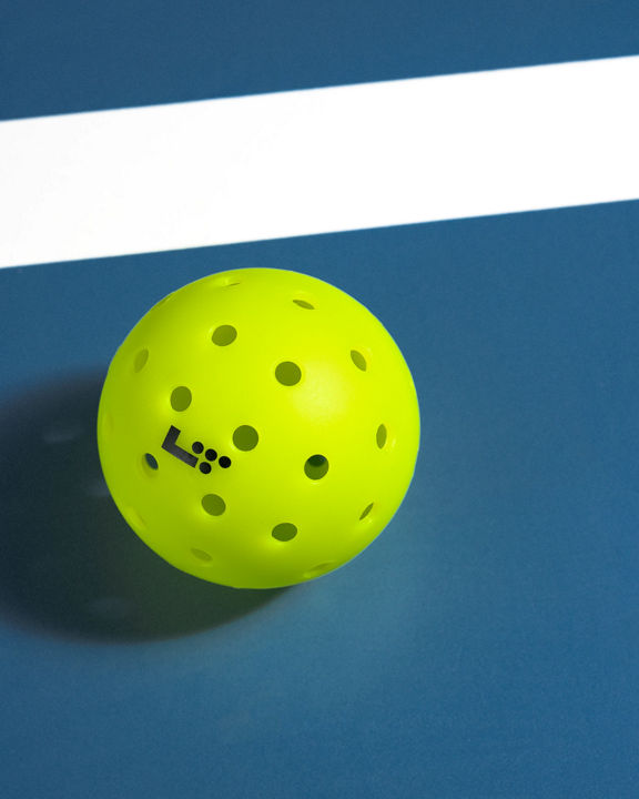 Closeup of a Life Time Branded pickleball placed on a blue court