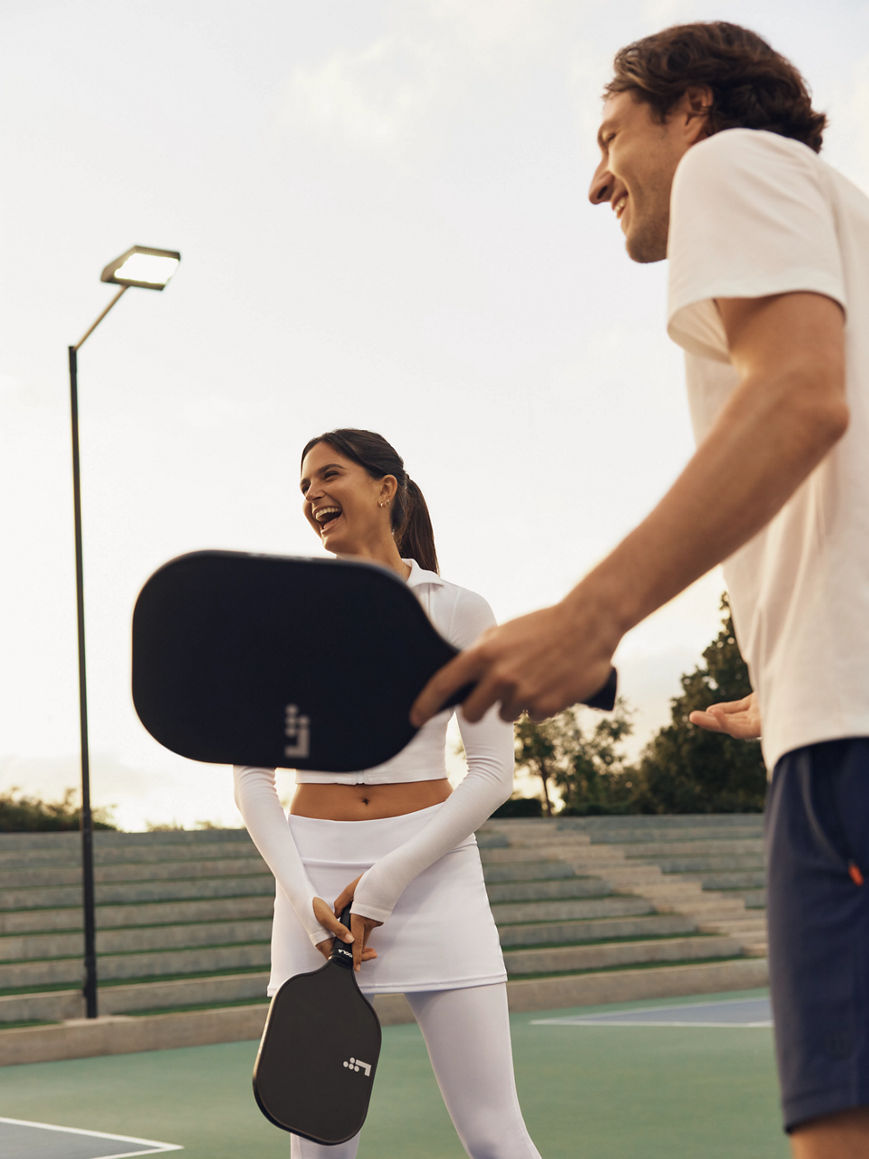 Two pickleball players laughing after a match