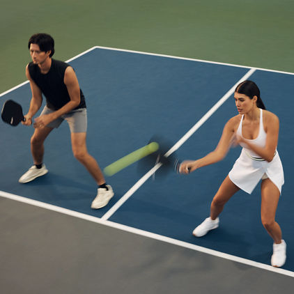 Action shot of a doubles pickleball match with one team at the kitchen