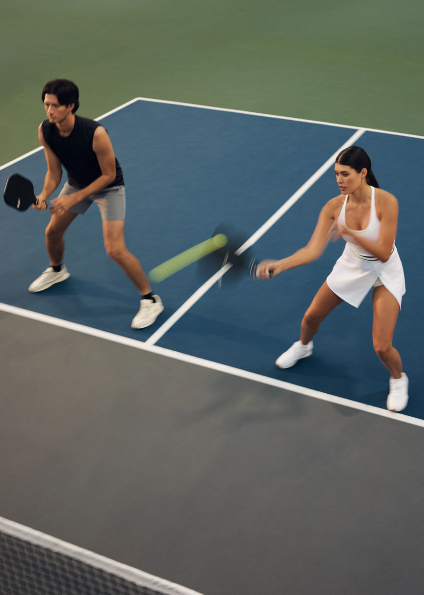 Action shot of a doubles pickleball match with one team at the kitchen