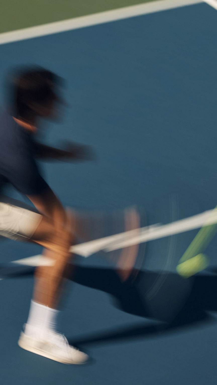 Stylized blurred image of a pickball player swinging at a pickleball