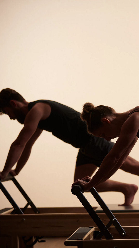 Life Time members exercising on reformers during a Pilates class