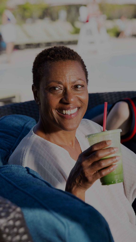 a group of older adults enjoy smoothies poolside