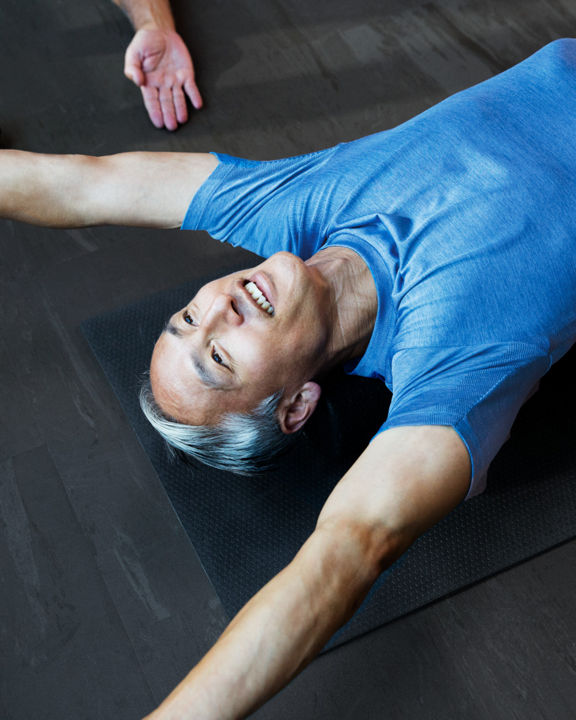 Male stretching with direction from a trainer during a personal training session