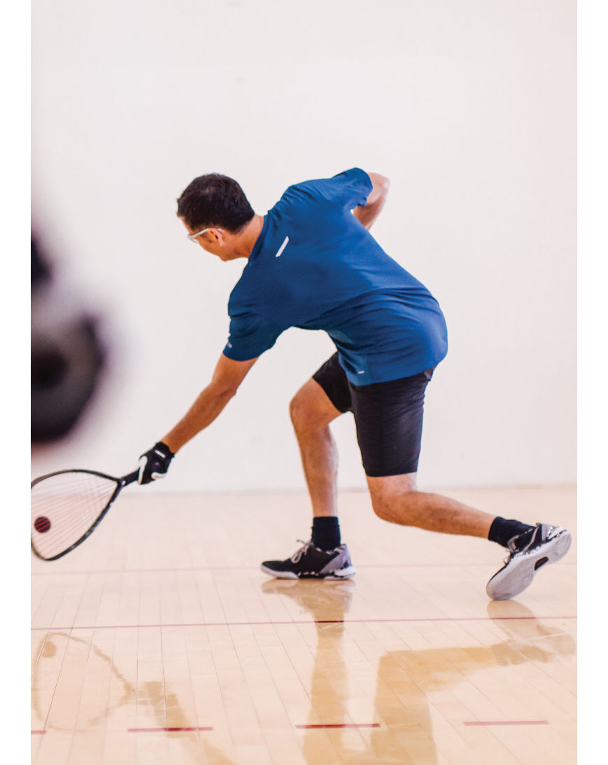 Two men playing racquetball on a racquetball court at Life Time