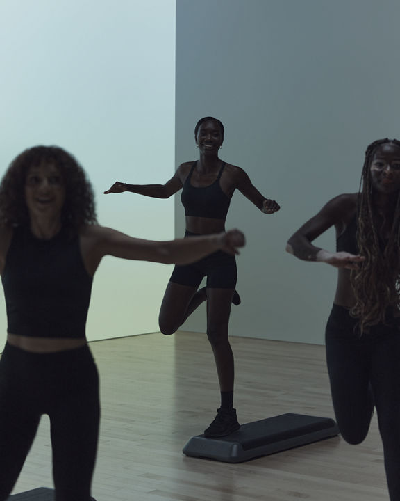 Remixx cardio dance class participants on step benches at Life Time