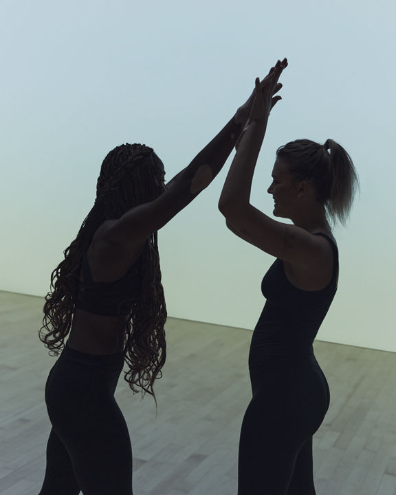 Remixx cardio dance class featuring silhouettes of two women high fiving