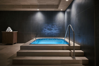 A softly lit cold plunge in a dark room, inviting relaxation and tranquility.