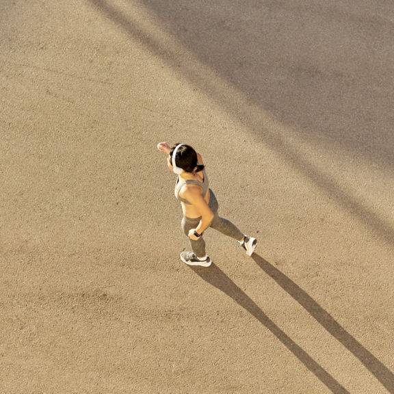 Top view of a young, attractive athletic woman running on city asphalt and training.
