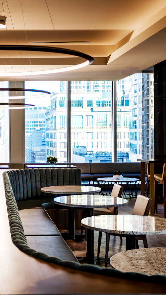 Tables, chairs, and booths in a warm dining environment