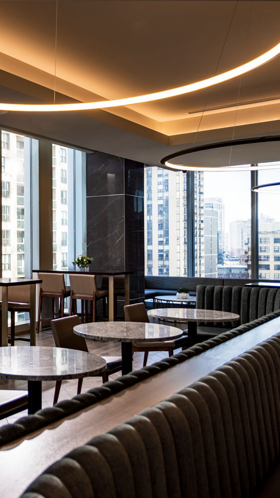 Tables, chairs, and booths in a warm dining environment