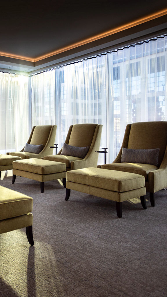 Cozy chairs in a seating area surrounded by floor to ceiling windows