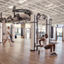 A man doing tricep dips on the edge of an outrace on an open fitness floor