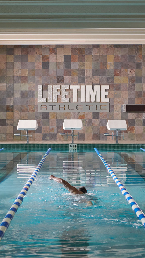 A man swimming laps in an indoor lap pool