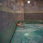 A man sitting and relaxing in an indoor whirlpool at the Life Time South Austin club location