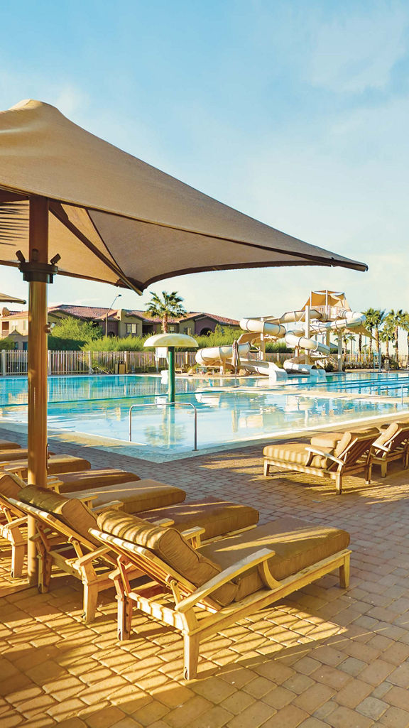 lounge chairs around an outdoor pool with waterslides