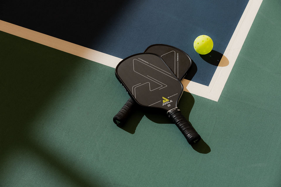 Pickleball paddles laying on a court