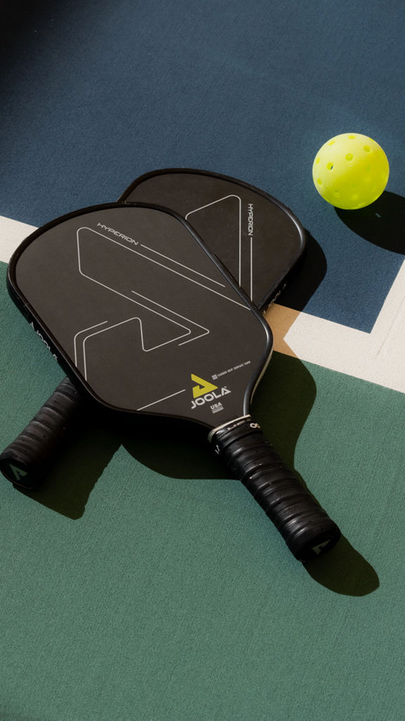 Pickleball paddles laying on a court