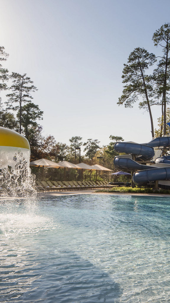 Outdoor leisure pool with waterslides and lounge chairs.