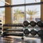 A fitness floor rack filled with kettlebells, weighted balls, and dumbells