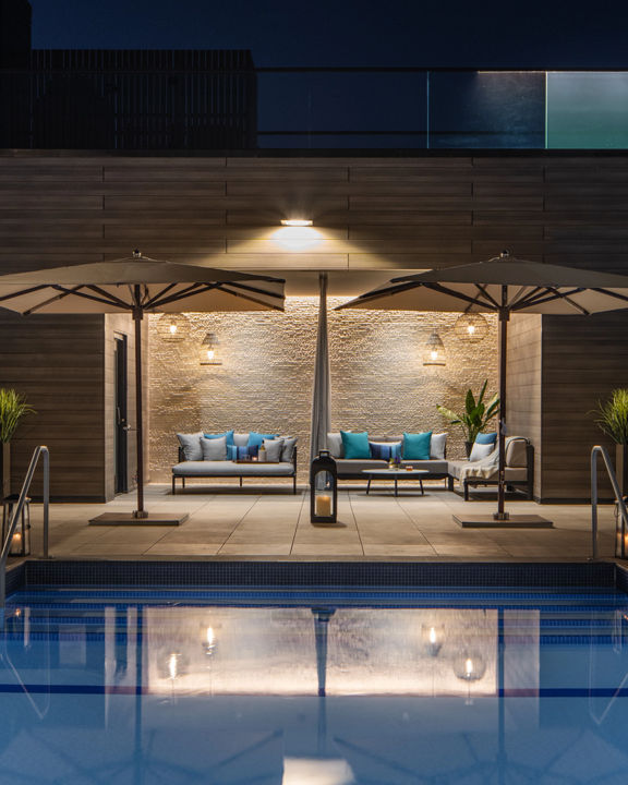 Outdoor rooftop pool and cabana area at night