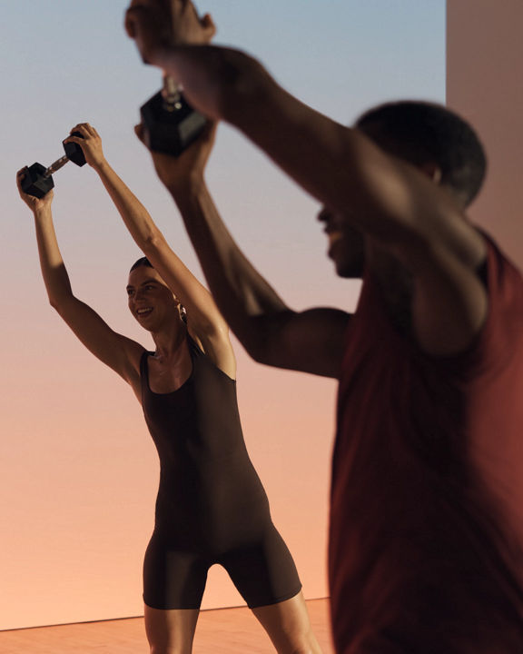 Two members lifting a barbell overhead in a Shred strength class