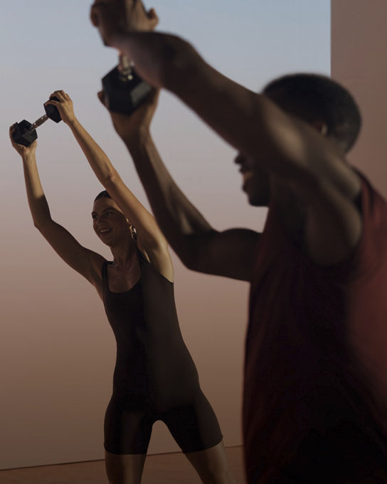 Two members lifting a barbell overhead in a Shred strength class