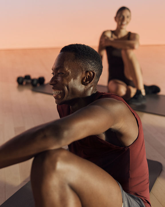 Close up of a Shred strength class participant smiling while seated on their mat