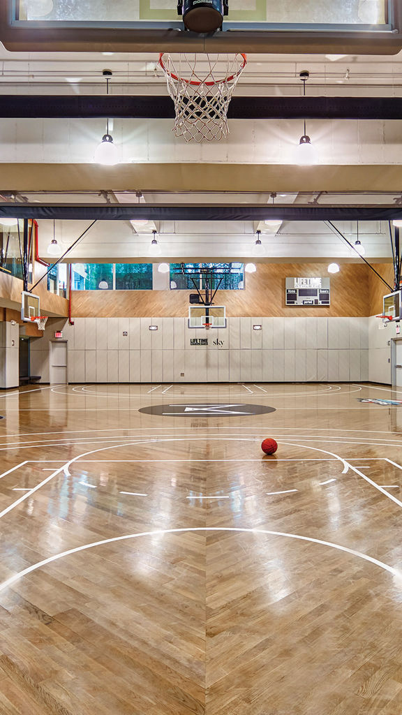 Brightly lit basketball court at the Life Time Sky club location