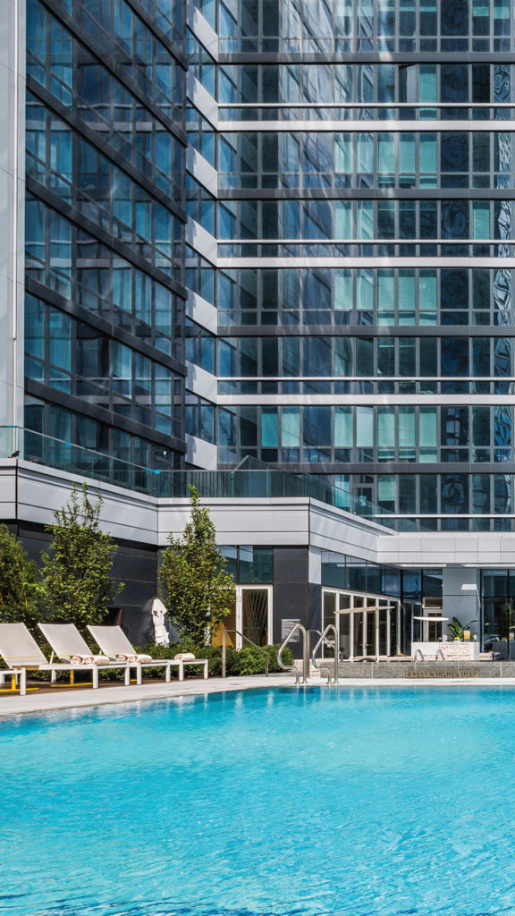 A rooftop pool deck outside a tall skyscraper building