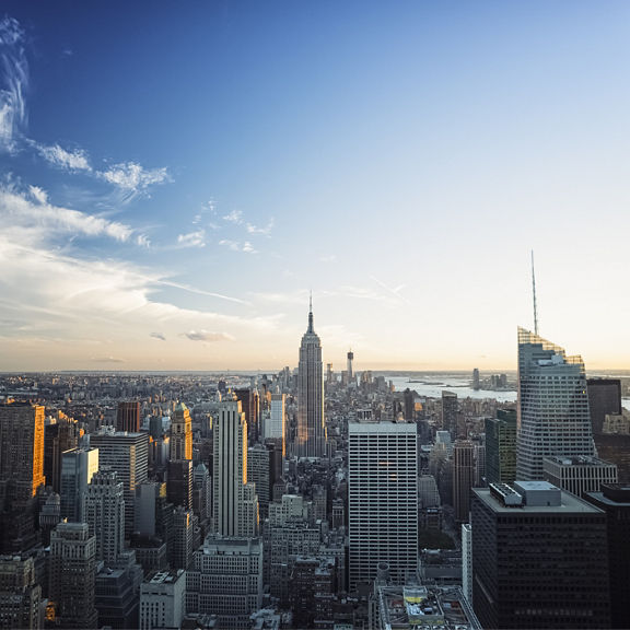 Manhattan skyline with Empire State Building taken from a window at sunset.