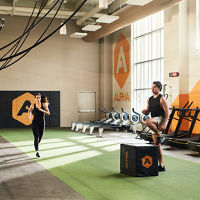 A male doing box jumps and a female jogging in an Alpha Studio