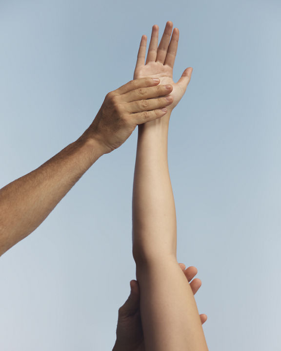 Sol yoga instructor guiding class participant into proper extended arm position at Life Time