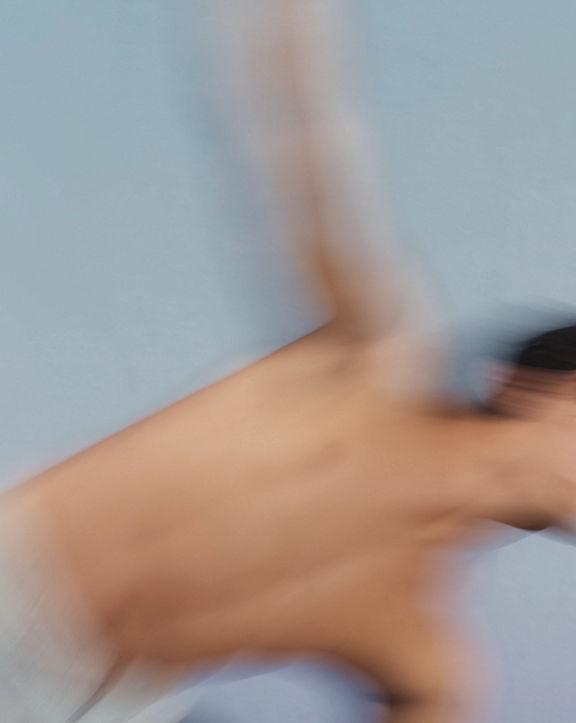 Stylized blurred image of a Sol yoga class participant moving into triangle pose at Life Time