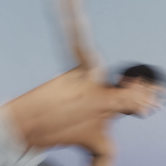 Stylized blurred image of a Sol yoga class participant moving into triangle pose at Life Time