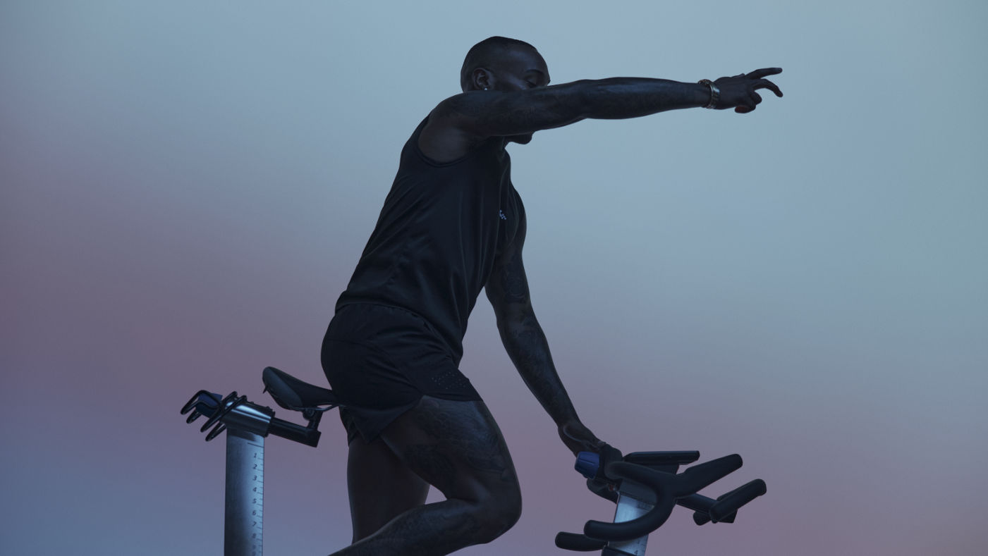 Cycling instructor in silhouette leading the AMP spin class