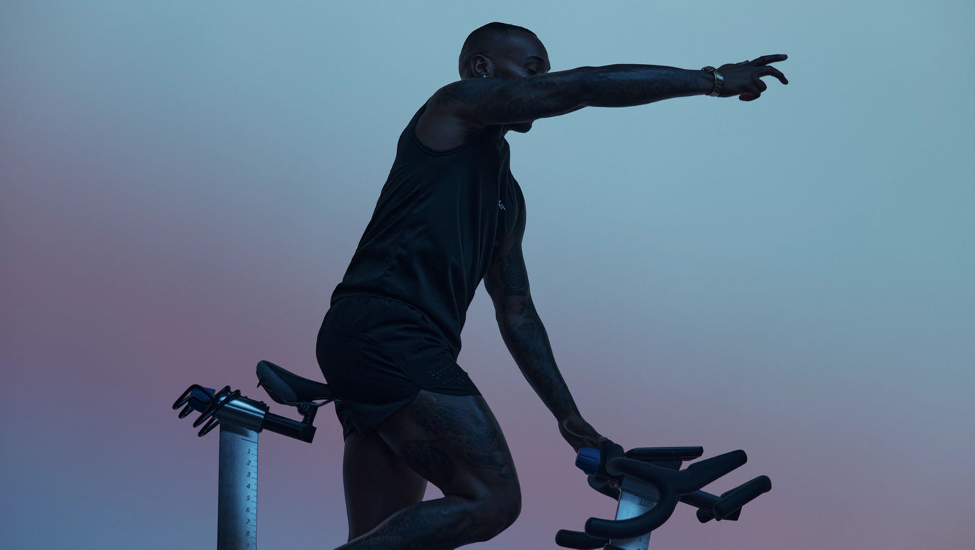 Cycling instructor in silhouette leading the AMP spin class