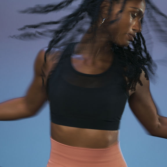 Close up of a Life Time member in motion during the sculpt portion of an AMP spin class