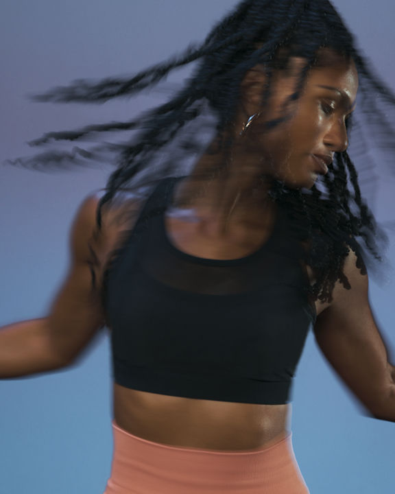Close up of a Life Time member in motion during the sculpt portion of an AMP spin class