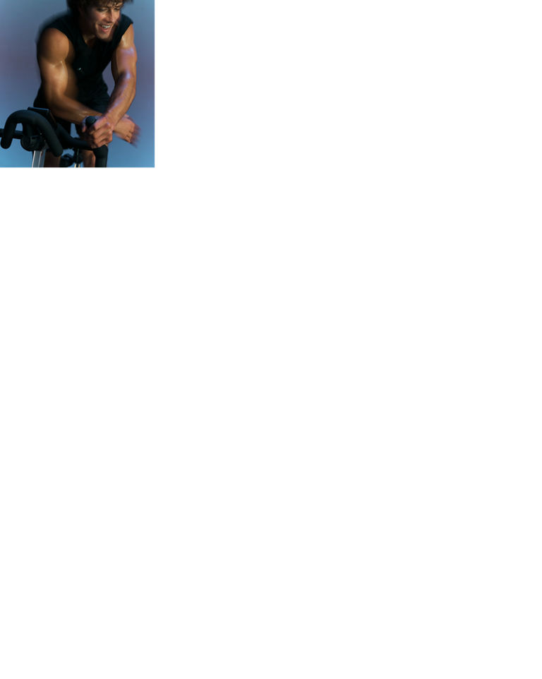 Artistically blurred close up of a cyclist leaning over their bike in an AMP spin class