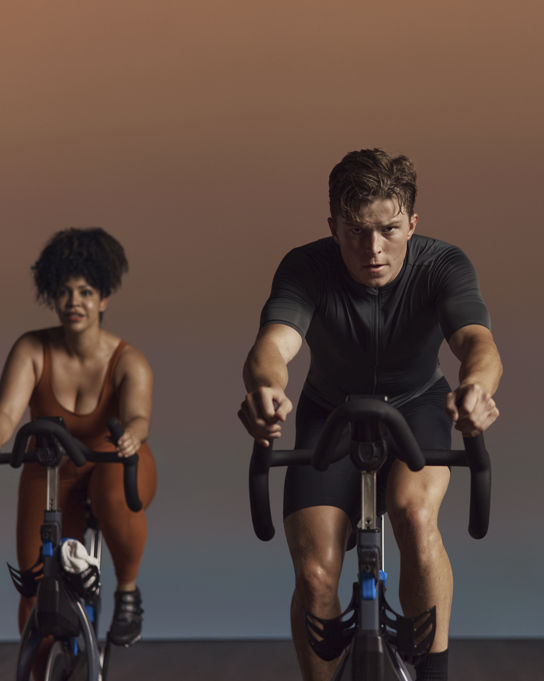 Three people with intense faces riding in an EDG spin cycle class