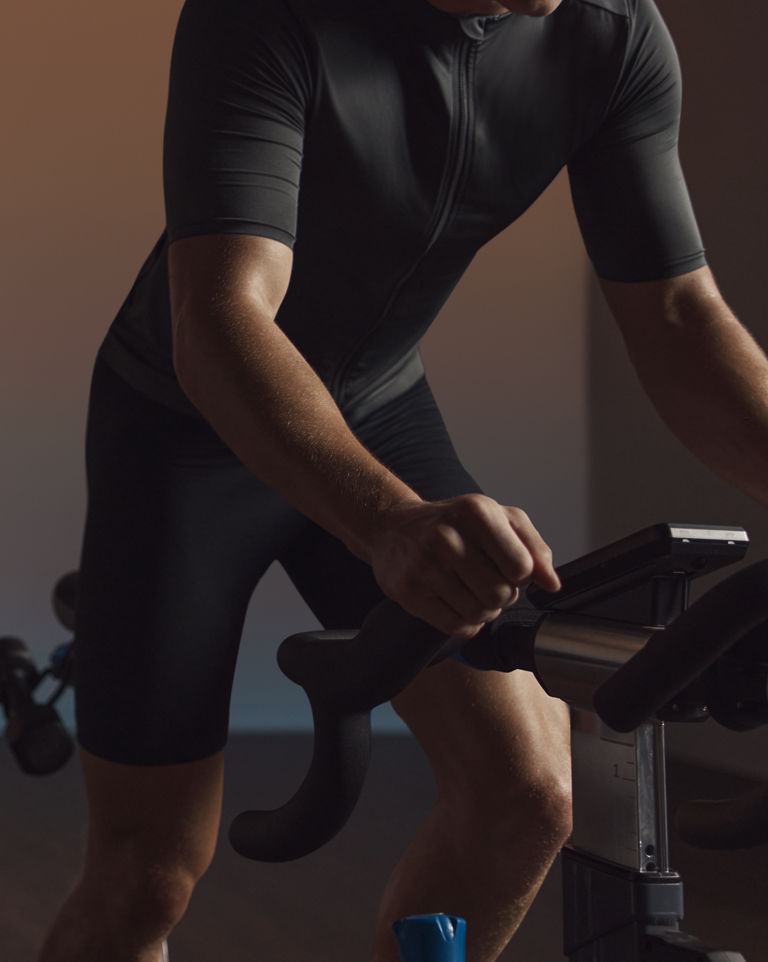 A cyclist seated on the bike riding in an EDG spin class